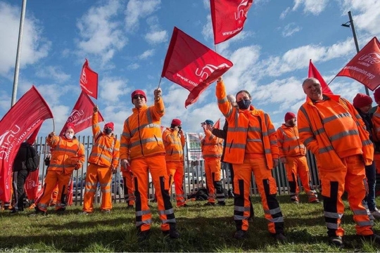A picture of a picket line with red flags