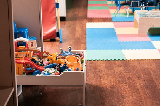 Colorful playroom with a toy storage unit filled with assorted toys on a wooden floor.