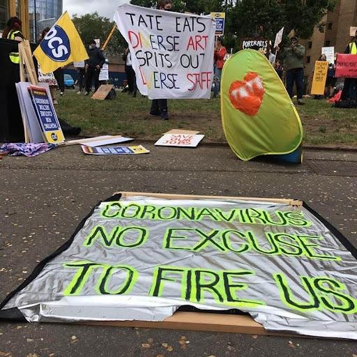 Picket line with banner on the ground that says "Coronavirus no excuse to fire us"